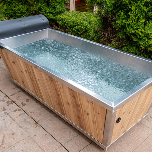 Wooden hot tub with metal exterior on a tiled patio